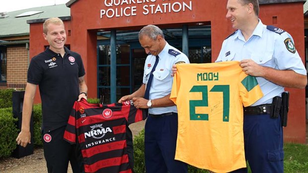 Donation &#8230; Aaron Mooy gives his Socceroos and Wanderers shirts to police at Quakers Hill.