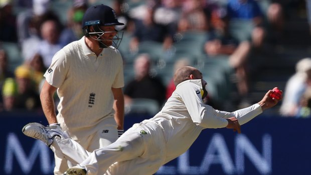 Australia's Nathan Lyon, front, is watched by England's Jonny Bairstow as he catches out England's Moeen Ali off his own bowling during the third day of their Ashes cricket test match in Adelaide, Monday, Dec. 4, 2017. (AP Photo/Rick Rycroft)