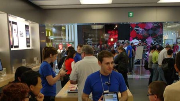 An Apple employee shows customers how the iPad works.