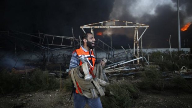 A Palestinian firefighter reacts as he tries to put out a fire at Gaza's main power plant.