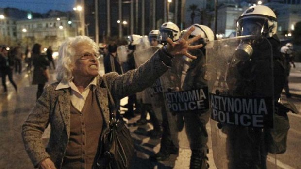 A protester argues with policemen during a rally at  Syntagma square in Athens after a pensioner's suicide.