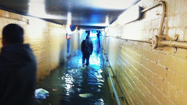 Commuters wade through the flooded tunnel.