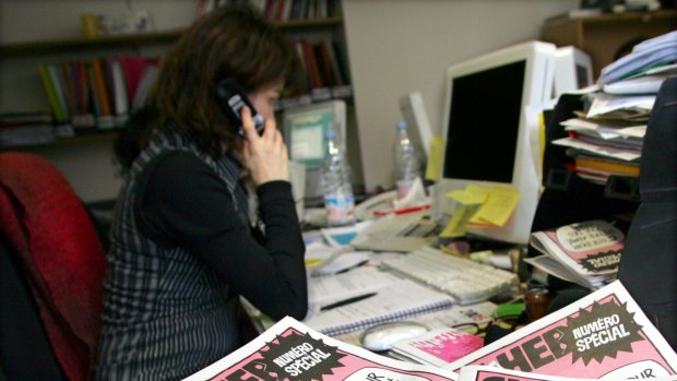 A journalist works in the Paris newsroom of French satirical weekly Charlie Hebdo in this February 9, 2006 file photo. 