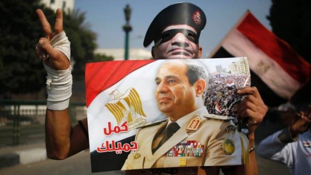 An Egyptian man holds a poster of coup leader Abdel Fattah al-Sisi.