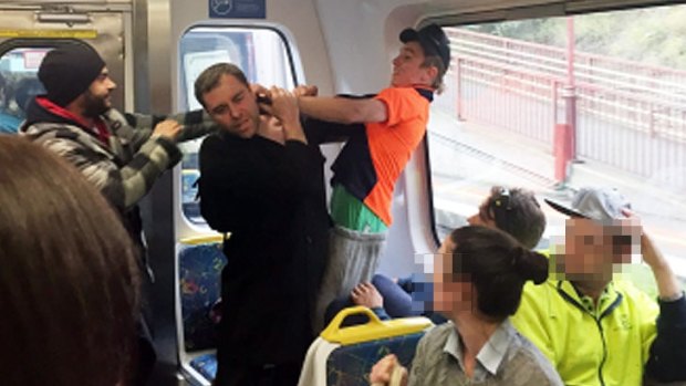 Jason Cias (centre) is assaulted by the man wearing orange after defending three women from abuse on a Craigieburn train.