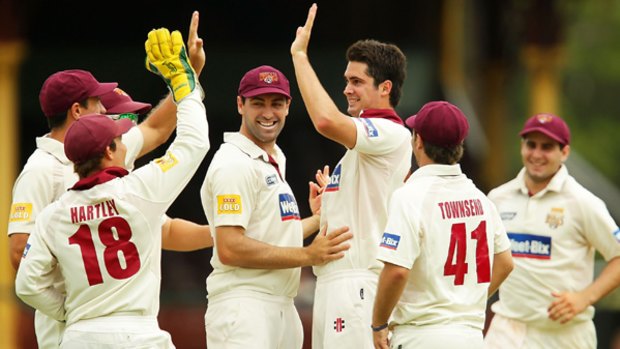Ben Cutting (centre) of the Bulls celebrates taking the wicket of Simon Katich of the Blues.
