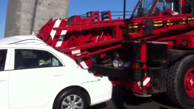 The boom of a crane lies wedged in the back of a car after a crash on the Anzac Bridge.