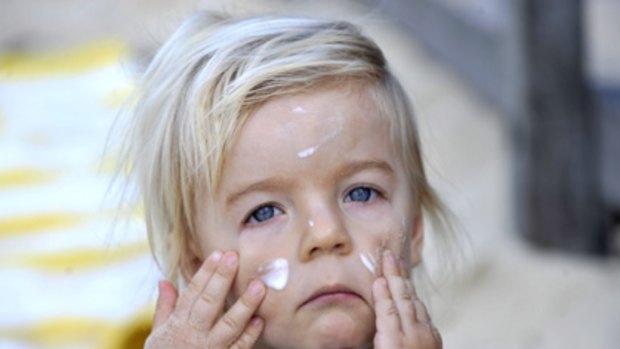 Care factor... Noah Ellison-Baker, 2, at Clovelly Beach yesterday, rubbing in sunscreen applied by his mum Katie.