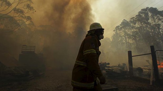 Eerie: A firefighter is surrounded by smoke in Lithgow on Thursday.