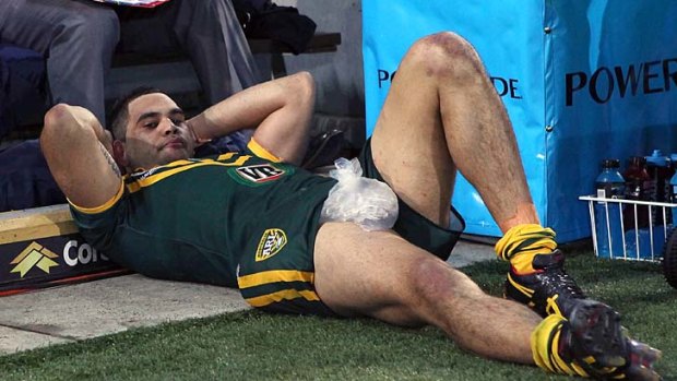 Greg Inglis of the Kangaroos lays dejected on the sidelineafter his injury in the Anzac Test.