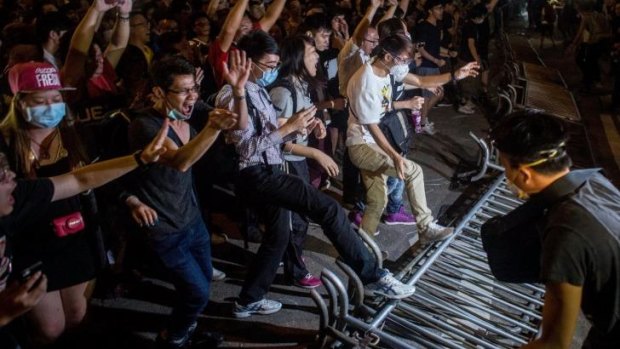 Street action: Protesters break down police barricades in Mong Kok early on Saturday.