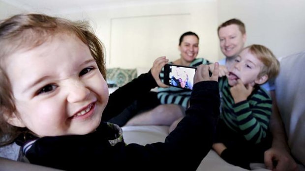 Antoinette and Kieron Maye, with their kids Zoe (2) and Patrick (5) who are playing with their parents iphones/androids/ipads at their home in Pemulwuy, Sydney.