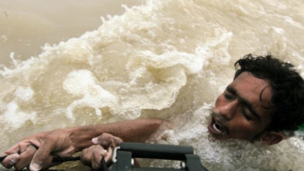A Pakistan navy raft rescues flood victim Mohammed Nawaz in Sukkur.
