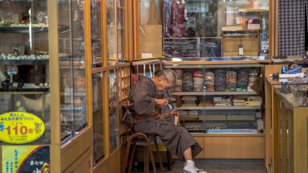 一个女人在浅草传统handicarfts商店工作。