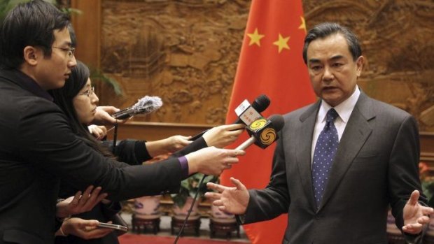 China's Foreign Minister Wang Yi speaks to journalists in front of a Chinese national flag after a meeting with Japan's ambassador to China at the Ministry of Foreign Affairs in Beijing.