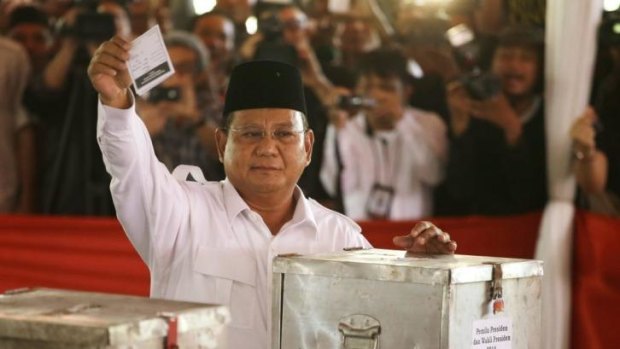 Former general Prabowo Subianto shows his ballot paper before voting.