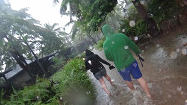 Australian tourists wade through rising waters at their Fiji resort.