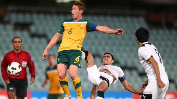 Kick in the pants ... Oliver Bozanic competes for the ball against Uzbekistan's Fozil Musaev at Parramatta Stadium last night in what proved to be another frustrating night for the Australians.