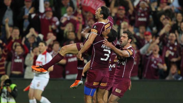 Justin Hodges lifts Billy Slater in the air after the fullback scored a try.