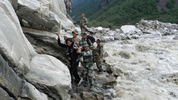 Rescue mission: Defence personnel help a civilian to safety beside a raging river following floods and landslides in the northern Indian state of Uttarakhand.