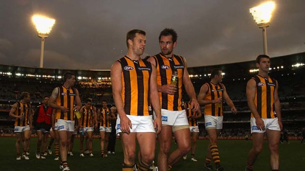 Sam Mitchell and Luke Hodge lead the Hawks off after their loss to Collingwood.