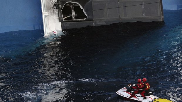 Firemen approach a hole created in the side of the stricken cruise liner Costa Concordia off the Isola del Giglio.