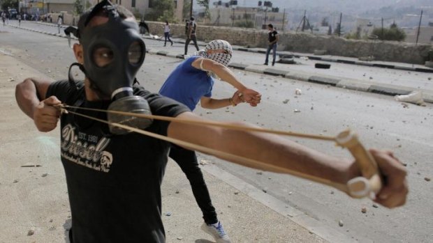 A Palestinian protester uses a slingshot to hurl stones at Israeli troops in Bethlehem.