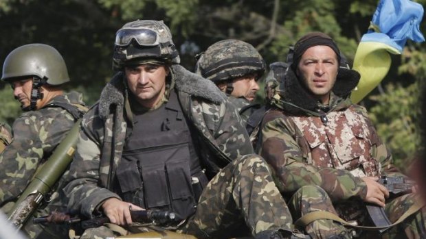 Facing Russian forces ... Ukrainian soldiers ride atop an APC near the village of Sakhanka, eastern Ukraine.