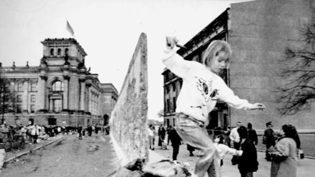 Tumbling down ... a girl plays on the rubble the day after East Germany began dismantling the Berlin Wall in February 1990.