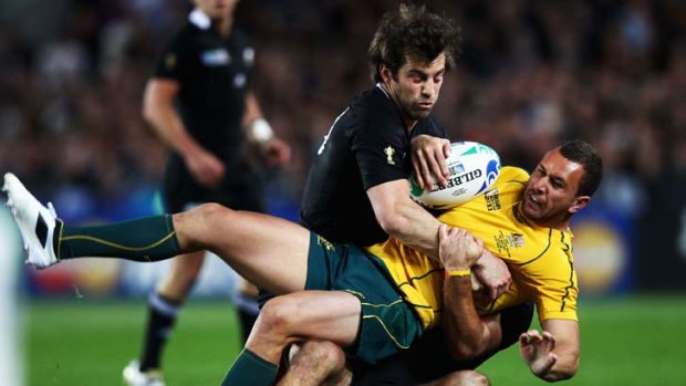 Tough time ... Conrad Smith of the All Blacks tackles Quade Cooper during their RWC semi final.