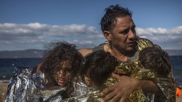 A man and three children arrive on the Greek island of Lesbos after a rough crossing from Turkey.