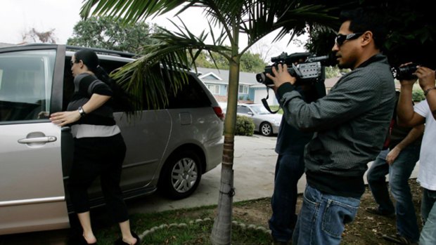 Nadya Sulema, the mother of octuplets, rushes to avoid paparazzi outside her mother's home.