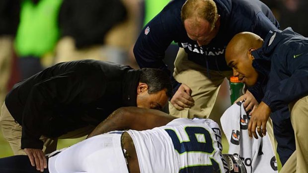 Chris Clemons of the Seattle Seahawks receives attention after being injured in the game against the Washington Redskins.
