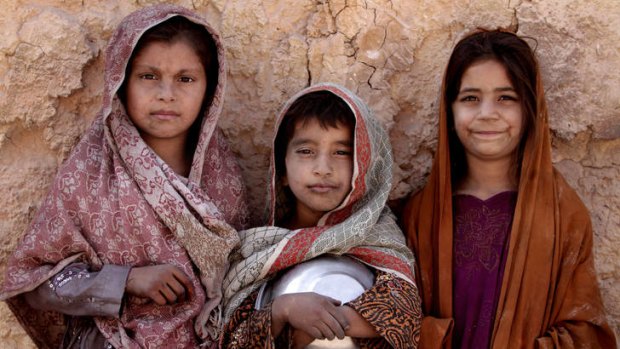 Sanjeeda, 8, left, Nagina, 7, center, Parwana, 8, right, pose for a photo during their working hours at a local brick factory in Jalalabad, Nangarhar province, Afghanistan.