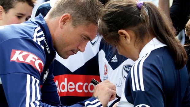 Good sign: Victory's star recruit, Harry Kewell, signs the jersey's of club supporters ahead of his encounter with Socceroos teammate, and Sydney FC drawcard, Brett Emerton.