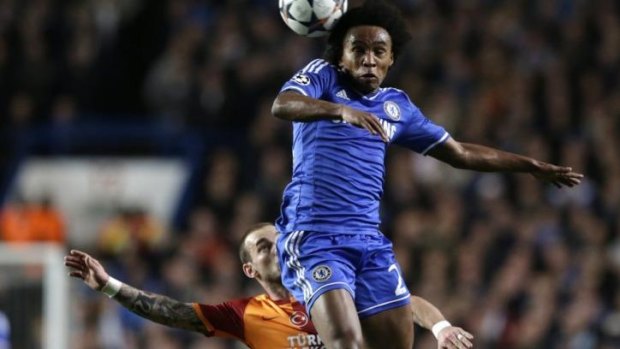 Willian leaps to head the ball as Galatasaray's Wesley Sneijder watches on.