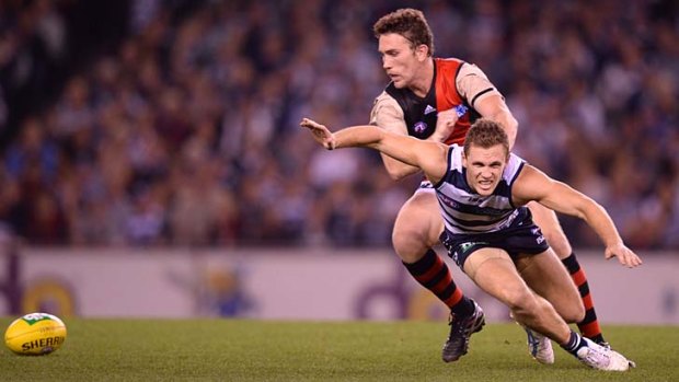 Geelong's Joel Selwood is pushed off the ball by Essendon's Heath Hocking.