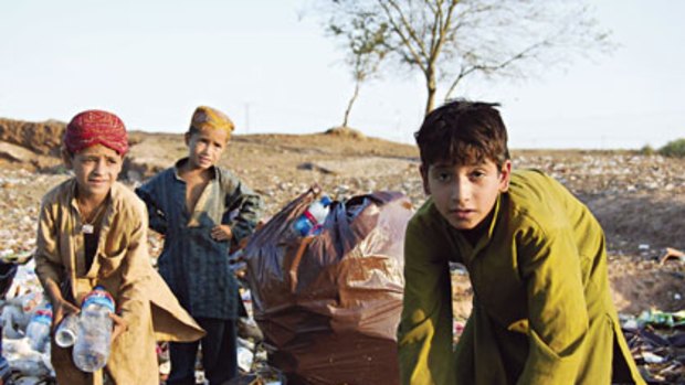 Sifting through the refuse of the rich ... Muhammad Yunis, left, and Habibullah,  right, scavenge for food with another child on a rubbish dump in Islamabad.
