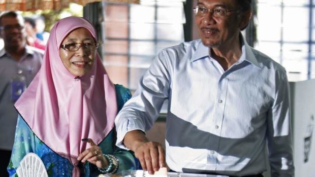 Favoured: Anwar Ibrahim and his wife cast their votes in the Malaysian election.