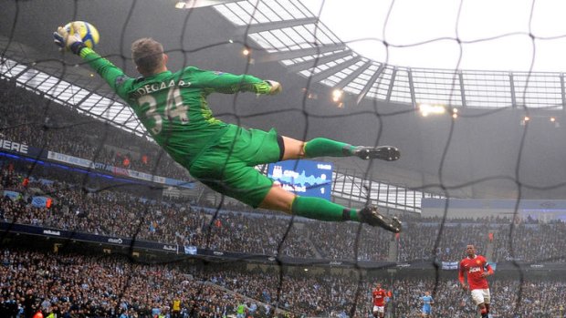 Manchester United goalkeeper Anders Lindegaard brilliantly saves a shot from Manchester City's Sergio Aguero.
