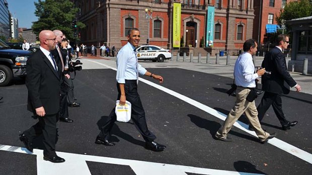 Out and about: Despite security scares, Barack Obama surprises bystanders on Friday with a rare stroll to grab lunch at a sandwich shop a block from the White House.