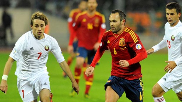 Spain's midfielder Andres Iniesta vies with Andrey Chukhley of Belarus during the World Cup qualifying match in Minsk.
