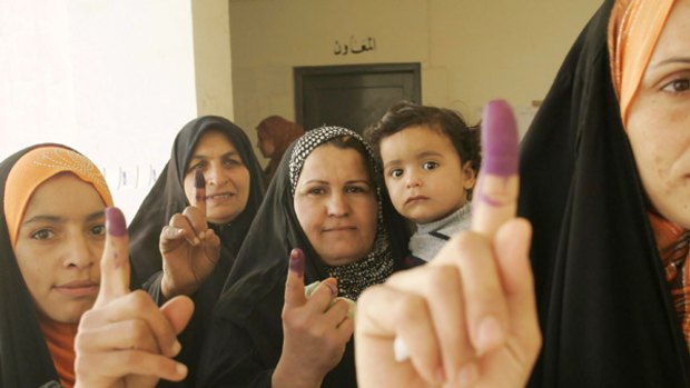 Iraqi women show their ink-stained fingers after casting their votes at a polling station in Baquba, northeast of Baghdad.