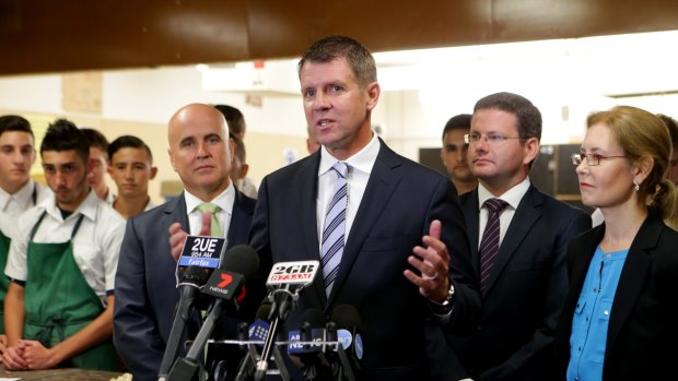 Mike Baird, flanked by ministers Adrian Piccoli and Gabriel Upton, says he expects Tony Abbott to prove wrong those who doubt him because of plummeting approval ratings.
