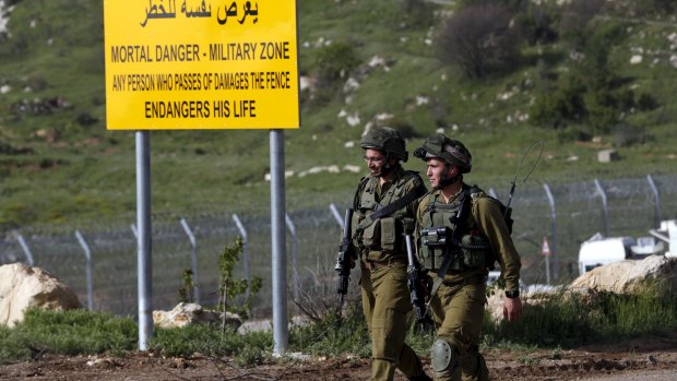 Israeli soldiers walk near the frontier with Syria on Monday. 