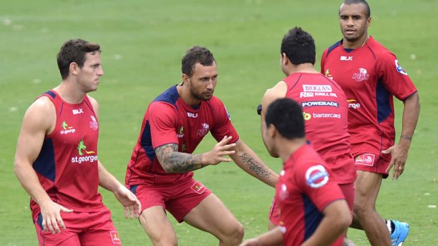 Quade Cooper prepares himself to tackle Anthony Faingaa during a Queensland Reds Super Rugby training session.
