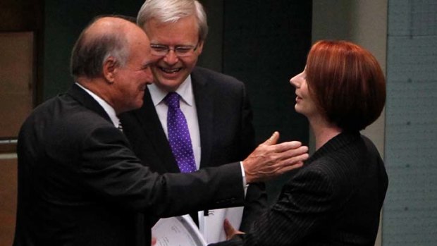 Light relief ... Julia Gillard embraces Independent MP Tony Windsor as Kevin Rudd looks on.