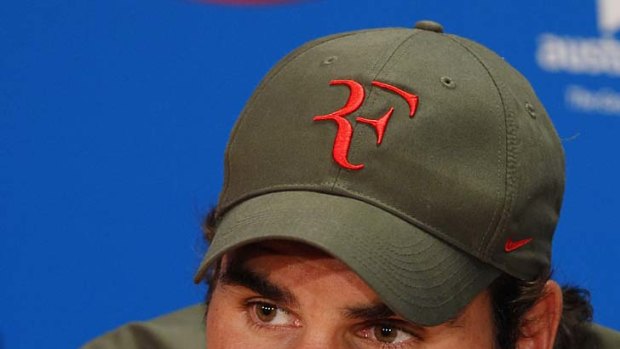 Chin wag: Roger Federer speaks to the media after his loss.