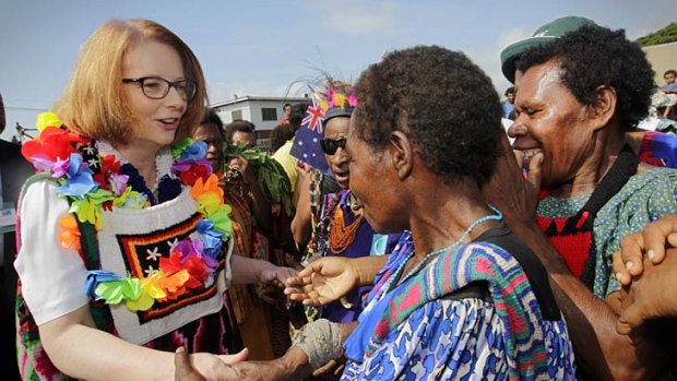 Meet and greet: Julia Gillard chats with locals as she visits markets in Port Moresby. She was later quizzed on visa restrictions for PNG's people.