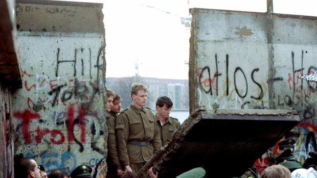 East German border guards on the Eastern side of the Berlin Wall as it comes down in November, 1989.